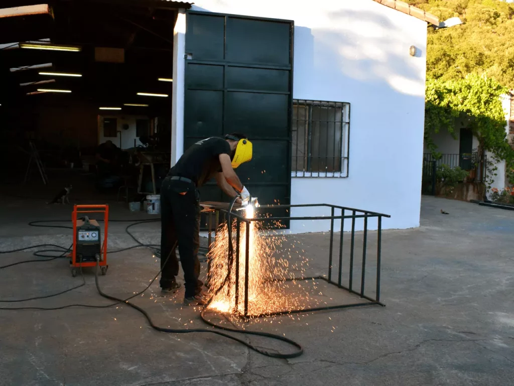 Trabajador soldando en el taller de construcciones metálicas